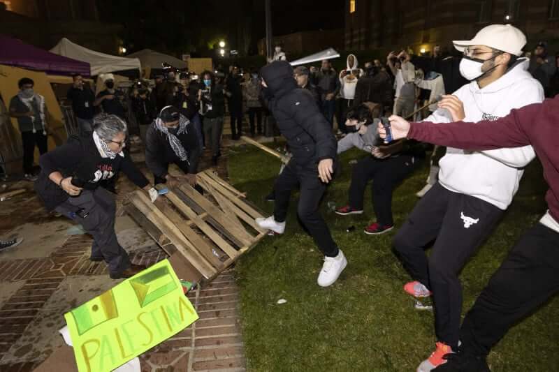 Estudantes brigando no campus da universidade. Objetos estão sendo arremessados