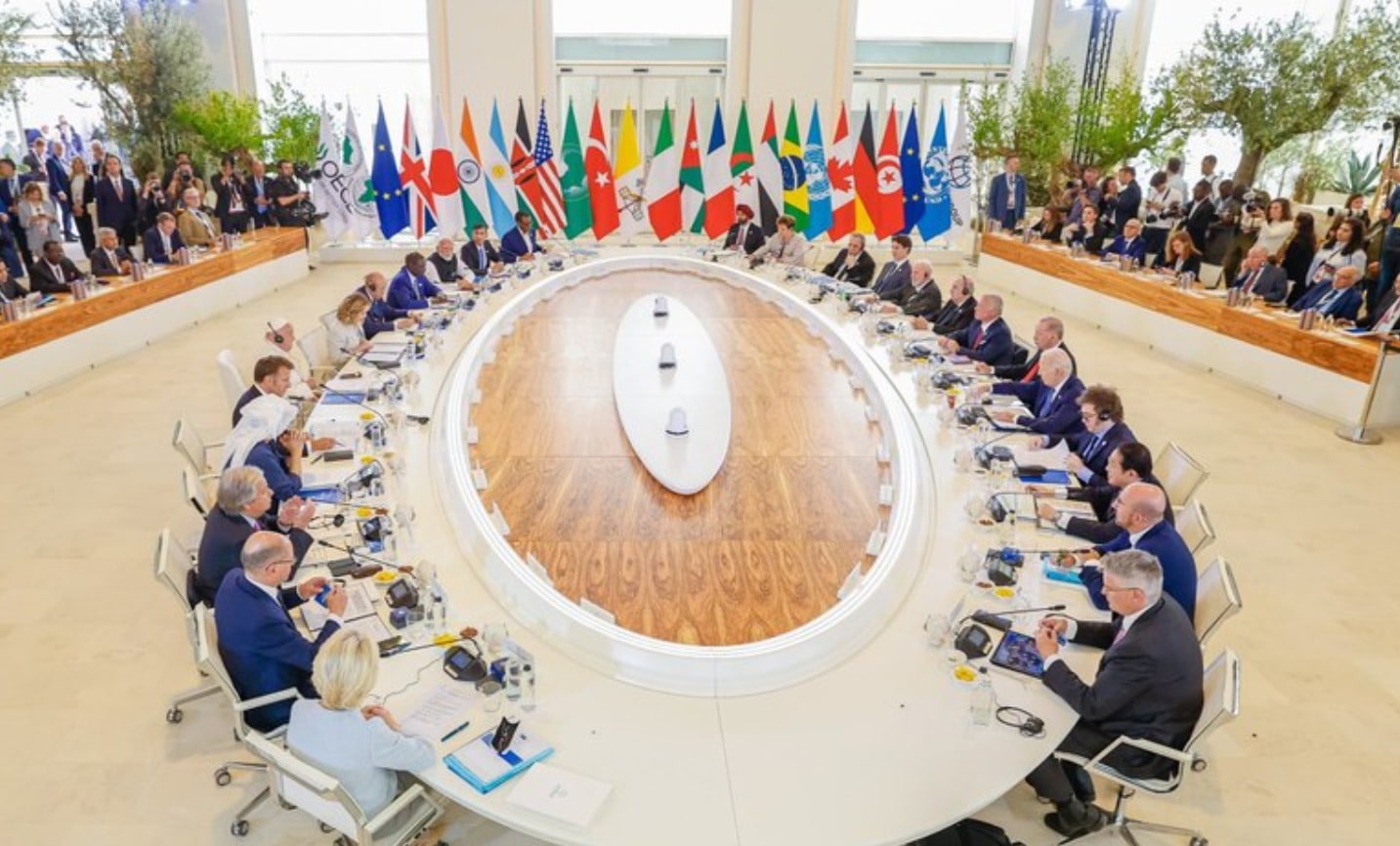 Imagem de representantes de países sentados em uma mesa, numa cúpula