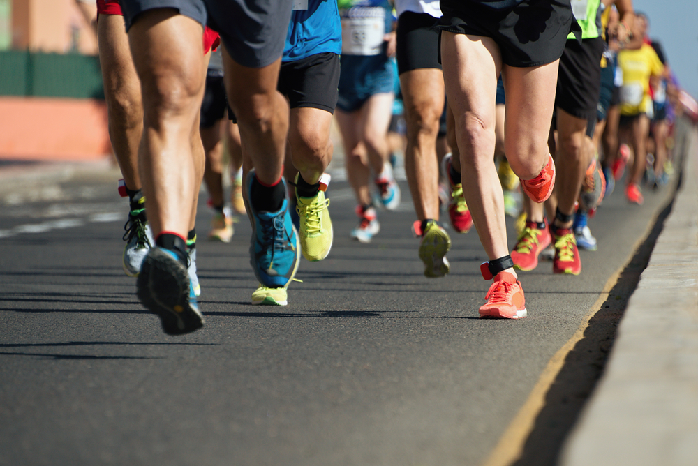 Imagem das pernas de pessoas correndo uma maratona